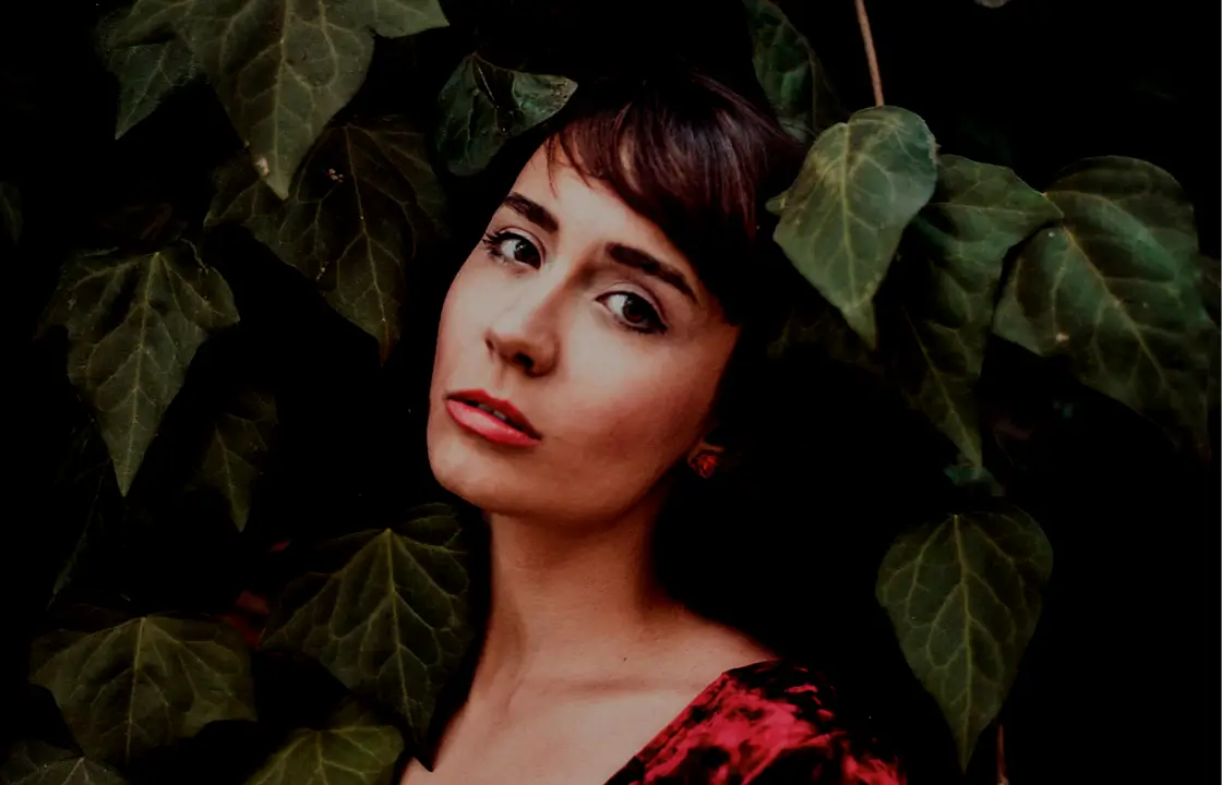 obscured woman headshot surrounded by leaves